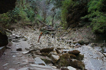 Prayer stone stacks among natural landscape of waterfall cascade and green forest park