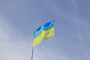 Ukrainian yellow and blue flag develops in the wind against the sky