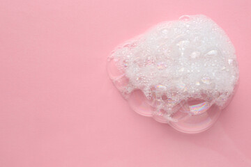 Drop of bath foam on pink background, top view. Space for text
