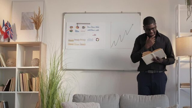 Business reading. Financial project. Professional learning. Cheerful man marketing manager book brainstorming planning statistics at office workplace.