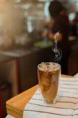 Ice coffee on table with cream being poured into it showing the texture and refreshing look of the drink