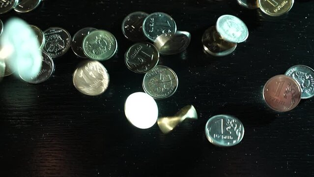 Russian coins fall from the hands on the table. Russian ruble.