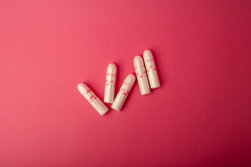 Medical female tampon on a pink background. Hygienic white tampon for women. Cotton swab. Menstruation, means of protection.