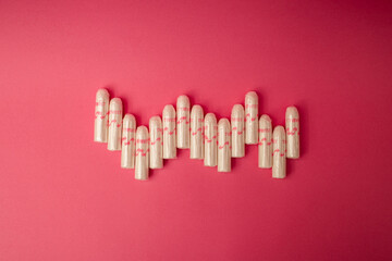 Medical female tampon on a pink background. Hygienic white tampon for women. Cotton swab. Menstruation, means of protection.