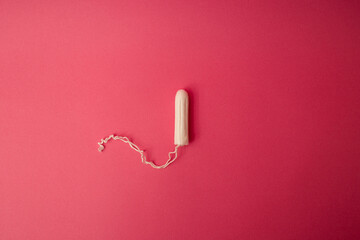 Medical female tampon on a pink background. Hygienic white tampon for women. Cotton swab. Menstruation, means of protection. - obrazy, fototapety, plakaty