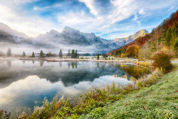 Outstanding autumn scene of foggy and sunny morning on Almsee lake