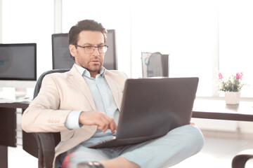 businessman using a laptop sitting at his Desk