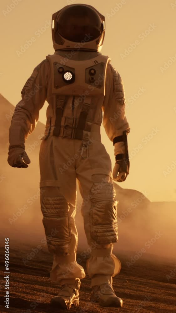 Wall mural astronaut on mars walking on the exploring expedition. in the background his base/ research station.