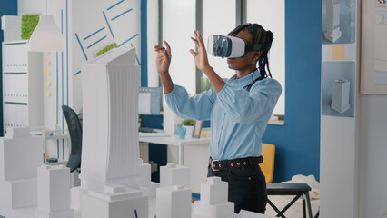 Woman architect wearing vr glasses to design construction layout and building model. Builder...