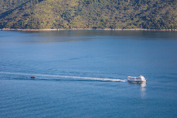 Obraz premium Ferry sailing across coastline, sea near Tolo Channel, Hong Kong