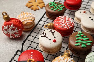 Beautifully decorated Christmas macarons on light grey table, closeup