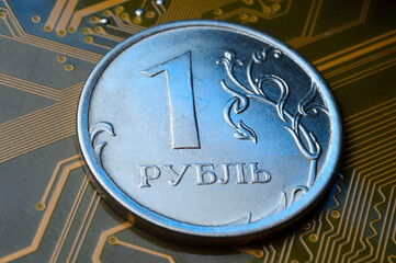 A coin with a face value of 1 ruble lies on a microcircuit. close-up. Translation of the inscription on the coin: "1 ruble" The concept of the digital economy in the Russian Federation