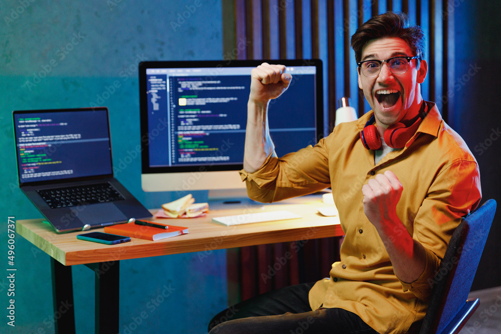 Wall mural young fun excited software database engineer it specialist programmer man in shirt work at home writ