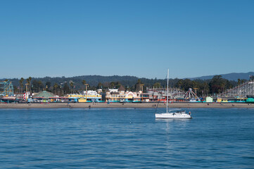 Fototapeta na wymiar Santa Cruz Beach seen from Santa Cruz Wharf with a white yacht