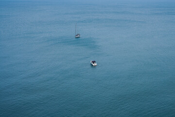 Two boats anchored in the open sea. Photo from above of vessels in the blue sea. Sailors life and summer vacation.