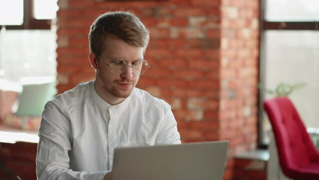 pensive man is filling resume online, sitting with laptop in cafe, freelancer and applicant for remote job vacancy