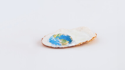 Fried poached egg and planet Earth on isolated pastel white background. Minimal abstract concept of...