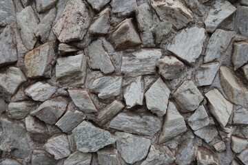 Close shot of whitish gray gravel pebble dash on the wall