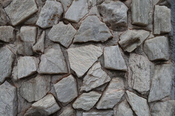 Closeup of whitish gray gravel pebble dash on the wall