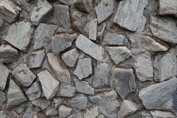 Rough surface of whitish gray gravel pebble dash on the wall