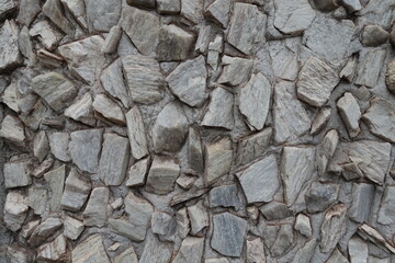 Surface of whitish gray gravel pebble dash on the wall