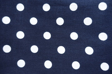 Top view of dark blue cotton fabric with white polka dot pattern