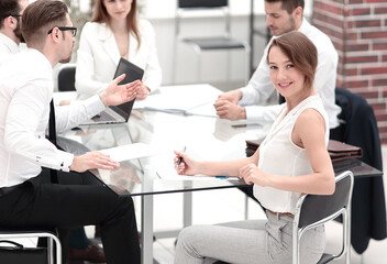 Fototapeta premium smiling employee and business team sitting at the Desk