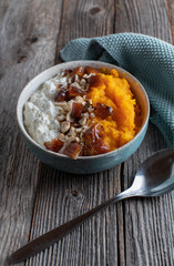 Fitness breakfast bowl with cottage cheese, pumpkin puree, dates and nuts