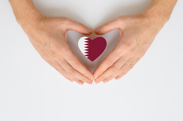 Fototapeta premium The national flag of Qatar in female hands.