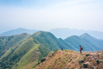 Hikers standing on peak of mountain, Lantau Island, Hong Kong