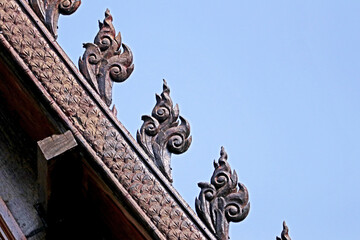 Fototapeta na wymiar Traditional Thai style wood craving on the roof of church in Thai temple