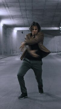 Serious Cool Young Hipster Man with Long Hair is Energetically Dancing Hip Hop on a Street Next to a Big Concrete Wall. Vertical Screen Orientation Video