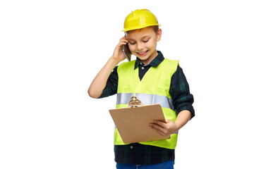 building, construction and profession concept - happy smiling little boy in protective helmet and safety vest with clipboard calling on smartphone over white background