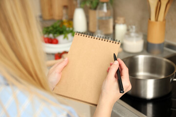 Concept of cooking with woman holds blank notebook and pen