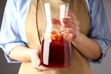 Woman in apron holds Jug of Sangria