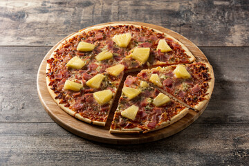 Hawaiian pizza with pineapple,ham and cheese on wooden table	