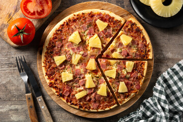 Hawaiian pizza with pineapple,ham and cheese on wooden table	