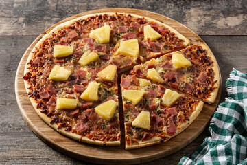 Hawaiian pizza with pineapple,ham and cheese on wooden table	