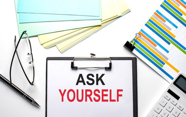 ASK YOURSELF text on paper sheet with chart,color paper and calculator