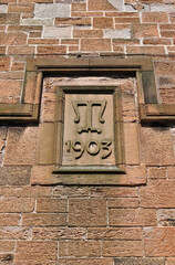 Close Up of Carved Stone Date Plaque on Old 20th century Building 