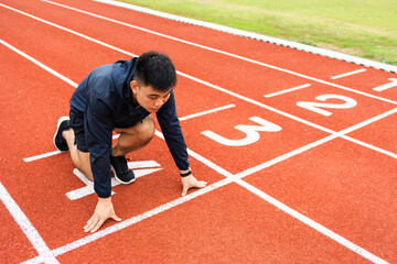Young handsome chinese man doing star pose before running exercise on track in sport stadium....