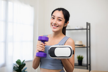 Fototapeta na wymiar Training holding dumbbell and virtual glasses. Young asian sport woman wearing sportswear workout with virtual simulated world. Into the future digital cyber universe. Future technology