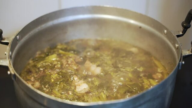 Cooking Thai traditional food Kaeng Thae Phoh, pork curry with water spinach boiled in the pot