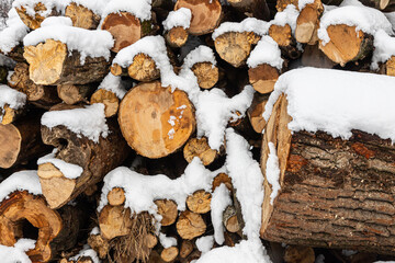 Snow covered firewood. Stack of wood cut. Snow on the timber stack. Wooden log store under snow