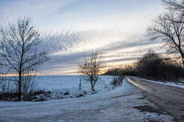 Winter road outside the city, cleared of snow in the countryside. Large snowdrifts on the side of the road