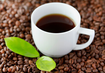 White cup of coffee close up on coffee beand background