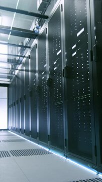 Camera Walk-Through Shot of a Working Data Center With Rows of Rack Servers.
