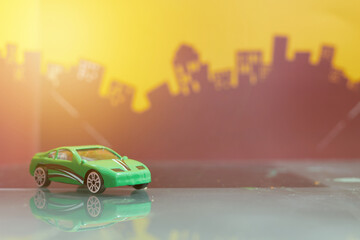 Green saloon car toy selective focus on blur city background