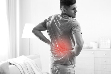 Man suffering from back pain at home. Bad posture problem