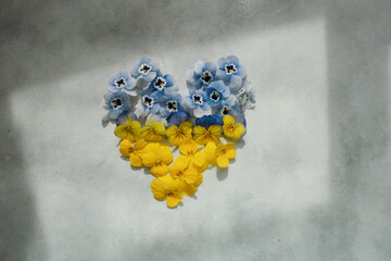 yellow and blue flowers laid out in the shape of a heart symbol of the Ukrainian flag